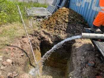 water flowing out of pipe underground